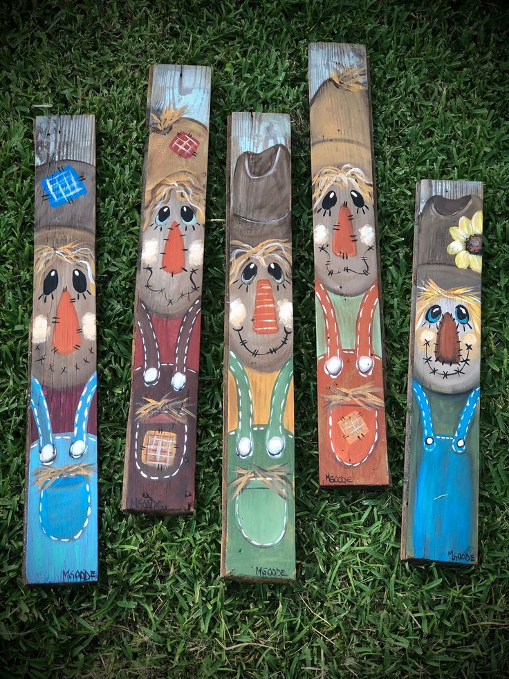 four painted wooden boards sitting in the grass