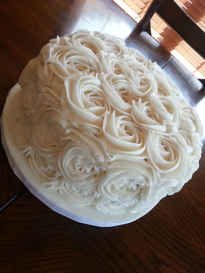 a large white cake sitting on top of a wooden table