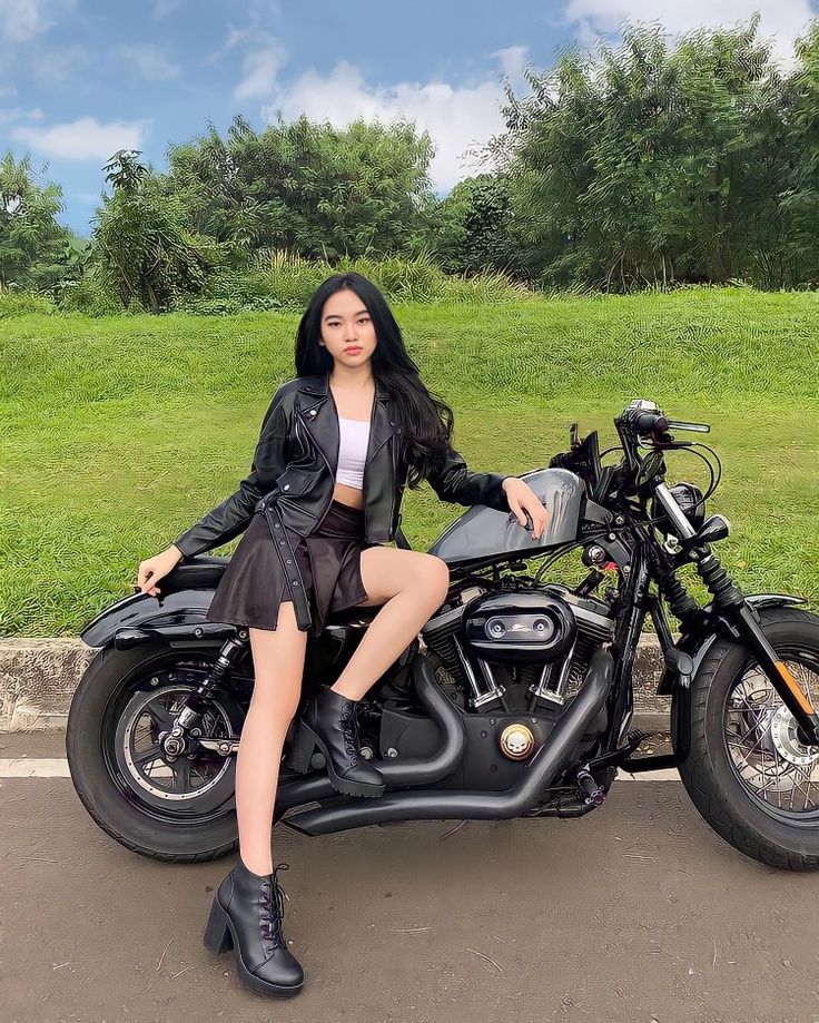 a woman sitting on top of a motorcycle