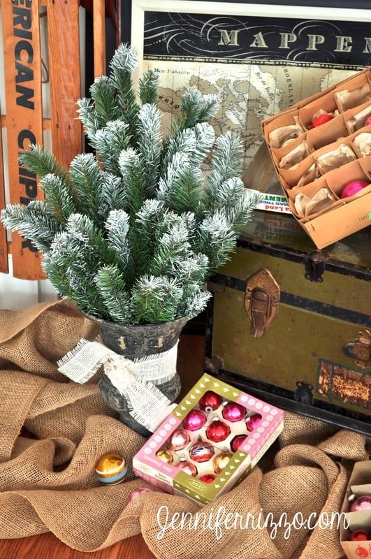 an old trunk is sitting on the floor next to a christmas tree and other decorations