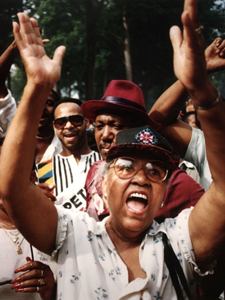 a group of people standing next to each other holding their hands up in the air