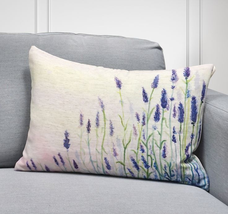 two pillows on a couch with lavender flowers