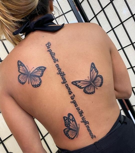 the back of a woman's shoulder with three butterflies on it, and an inscription written in cursive writing