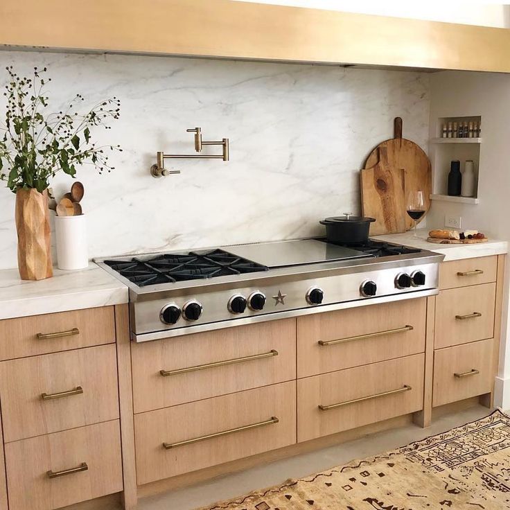 a stove top oven sitting inside of a kitchen next to wooden cabinets and counter tops