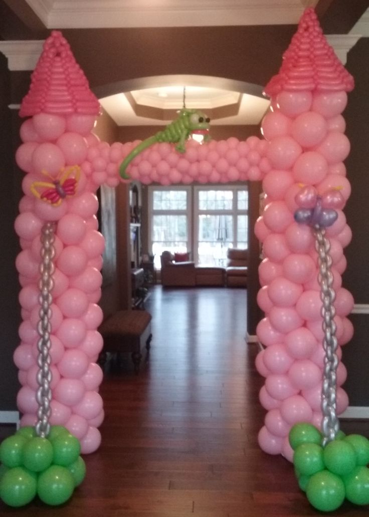 an arch made out of balloons with green and pink decorations