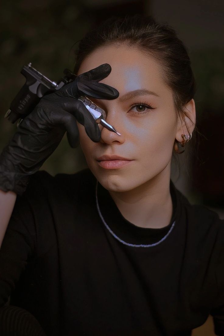 a woman with black gloves on her head and nails on her face, looking at the camera