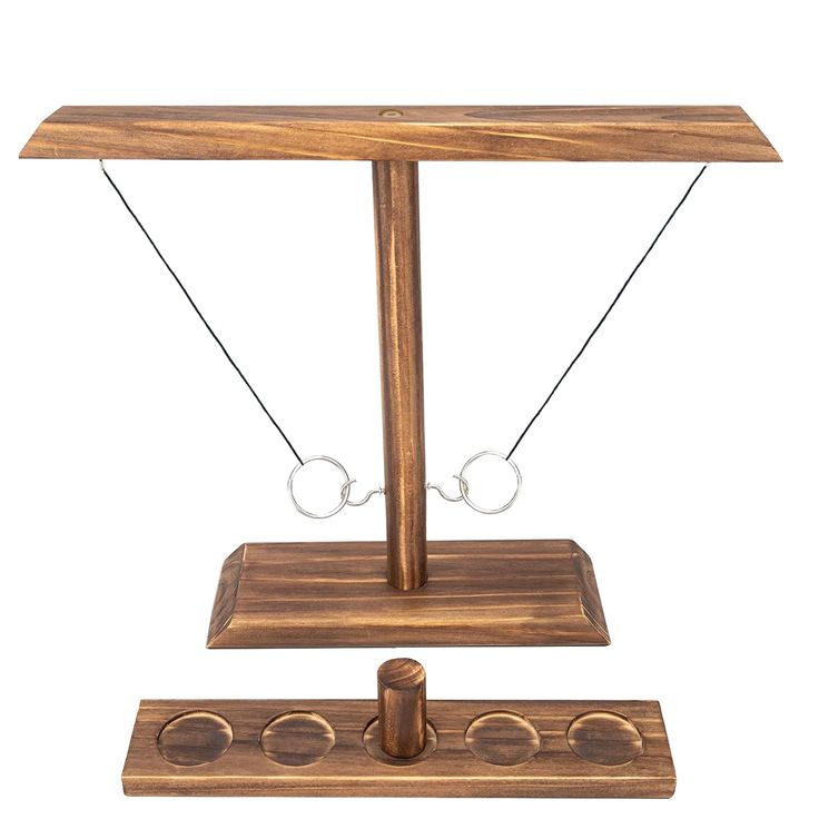 an old fashioned wooden balance scale with two rings on each side and four holes in the middle