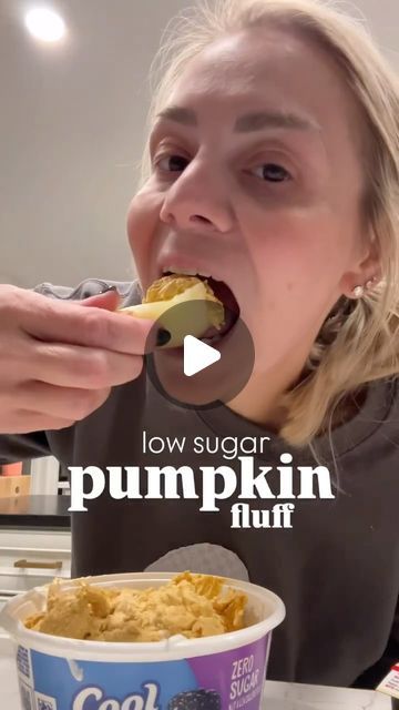 a woman eating food from a bowl in front of her face with the caption low sugar pumpkin yogurt