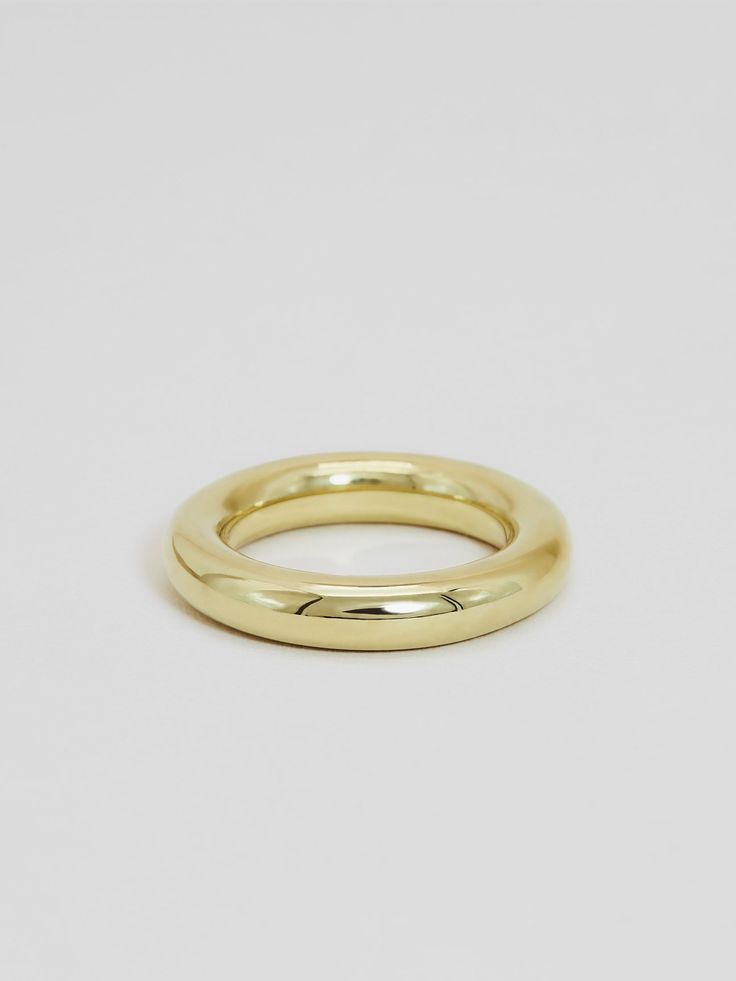 a yellow gold wedding ring on a white background