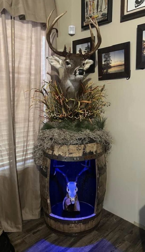 a deer head mounted to the side of a wooden barrel