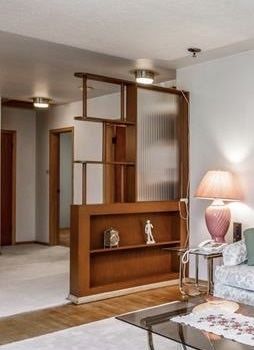 a living room filled with furniture next to a white rug on top of a hard wood floor