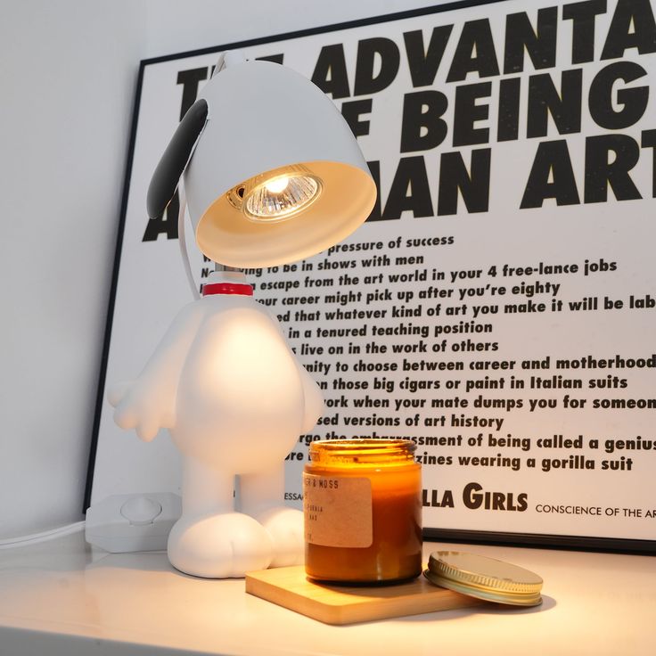 a white lamp sitting on top of a table next to a jar of peanut butter