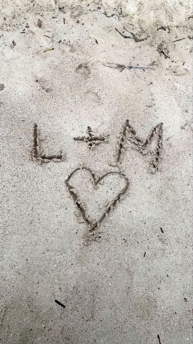 i love my mom written in the sand with a heart and arrow drawn on it