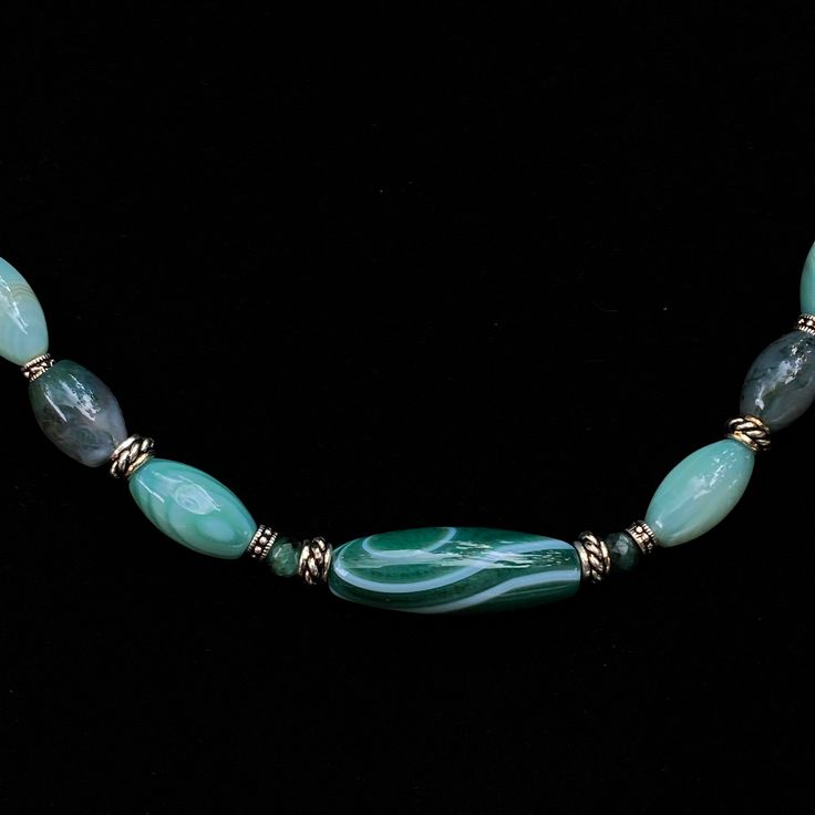 Genuine green agates and emeralds 18" total length, not adjustable, metal is silver plated alloy The emeralds are the two surrounding the big center piece agate Designed to gem up the guys, but also can be unisex We do our best to choose each stone carefully and purposefully for every piece.. However there might be slight differences in color size shape and clarity which makes each item unique and one of a kind.Each piece of jewelry will come in a colored drawstring bag for it’s protection and s Spiritual Green Agate Jewelry, Oval Jade Gemstone Beads Jewelry, Adjustable Green Stone Necklace, Turquoise Jewelry With Natural Green Onyx Stones, Turquoise Jewelry With Natural Stones In Green Onyx, Green Agate Jewelry With Natural Stones, Green Agate Jewelry For Healing, Adjustable Green Agate Jewelry, Green Onyx Round Beads Jewelry