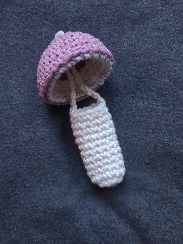 a crocheted pink and white baby booties laying on top of a gray blanket