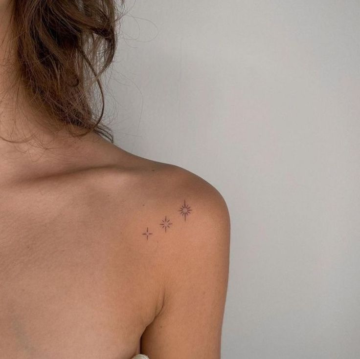 the back of a woman's shoulder with small stars on it