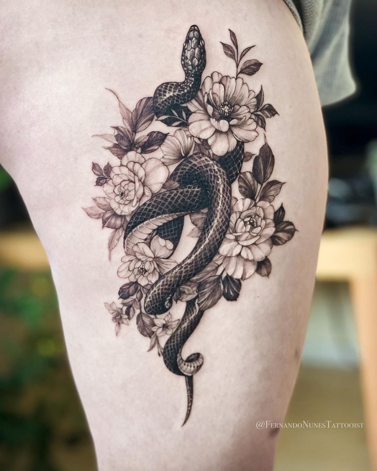 a woman's thigh with a snake and flowers on it