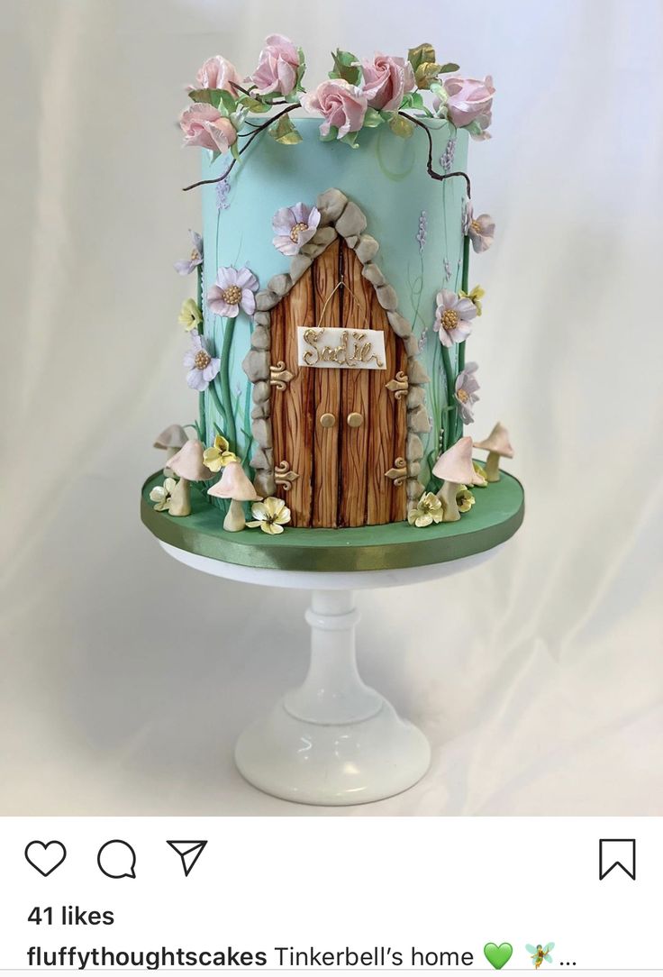 a cake that looks like a fairy house with flowers on the outside and a door in the middle