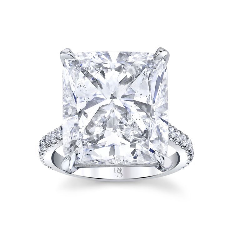 a princess cut diamond engagement ring with pave diamonds on the shoulders and sidestones