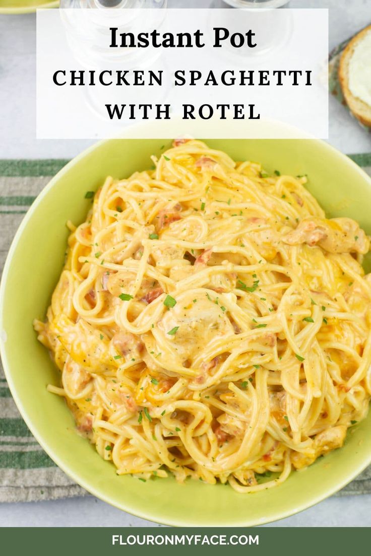 a green bowl filled with chicken spaghetti and sauce next to toasted bread on the side