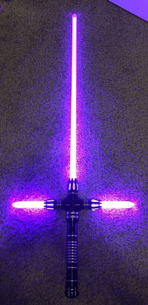 a purple light saber is lit up in the dark