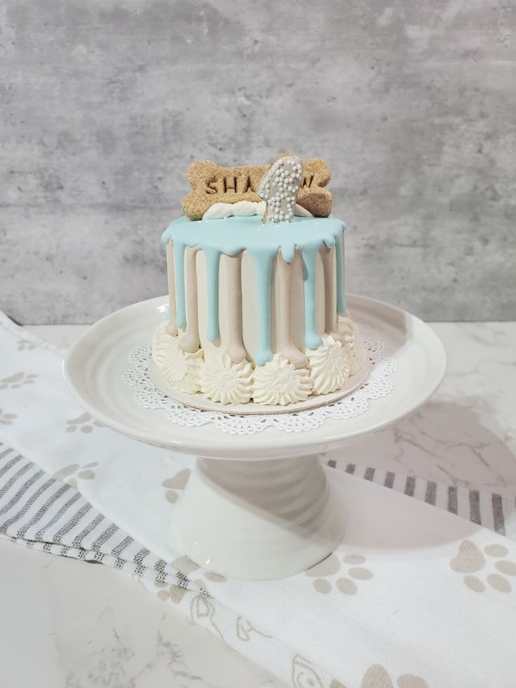 a white cake with blue icing and cookies on top