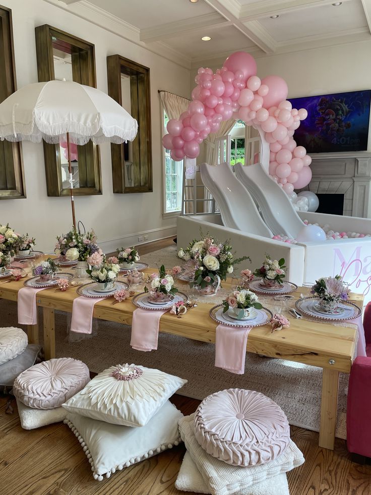 a table set up with pink and white decorations