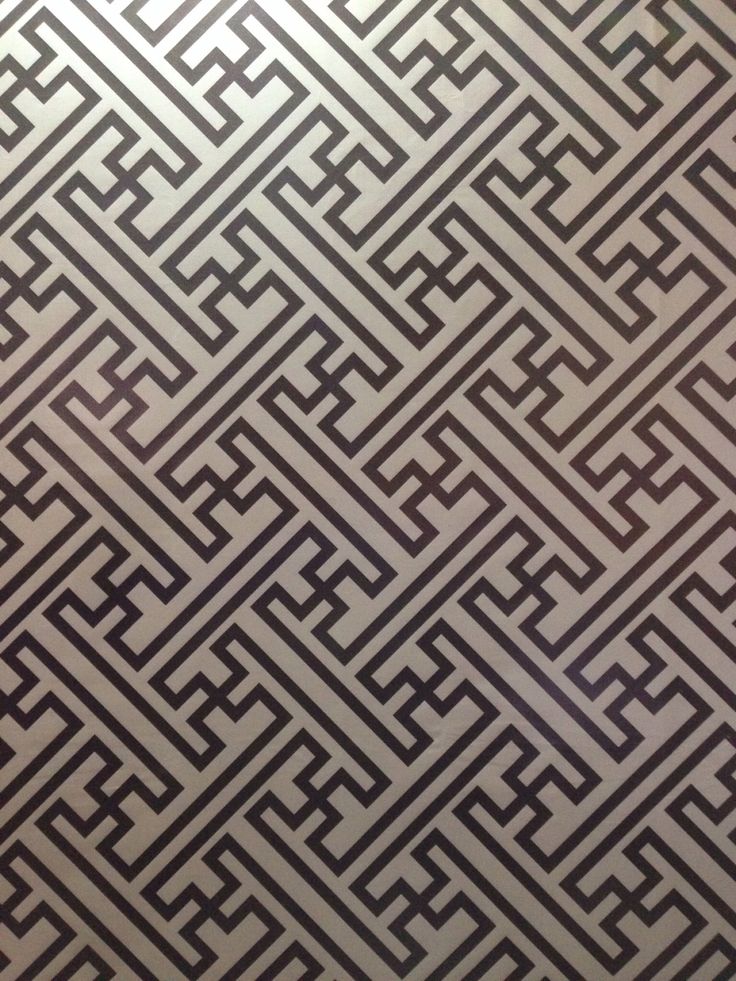 an intricate pattern is shown in black and grey colors on the wall, as if it were made out of metal