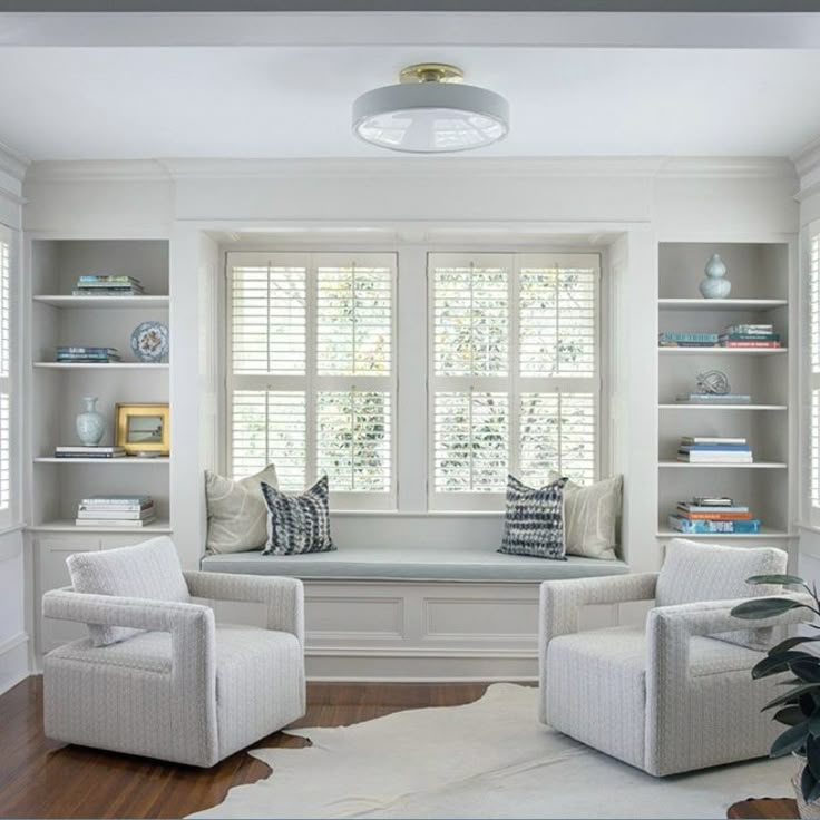 a living room with two chairs and a window