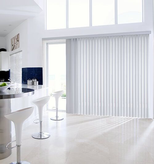 a modern kitchen with white counter tops and bar stools