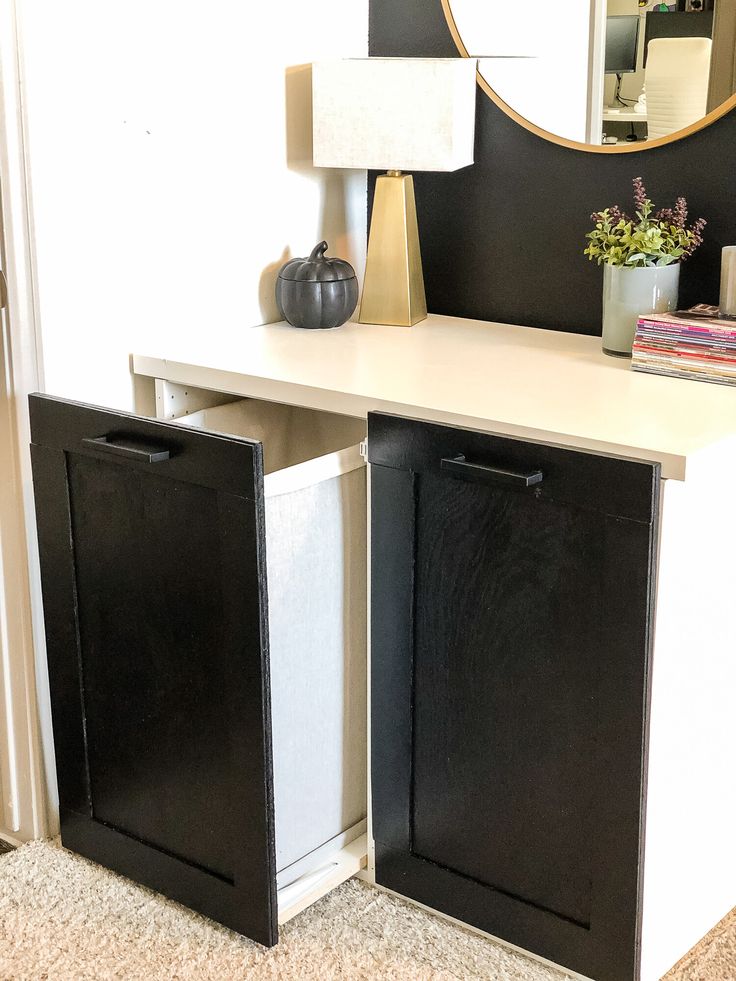 two black and white cabinets in front of a mirror