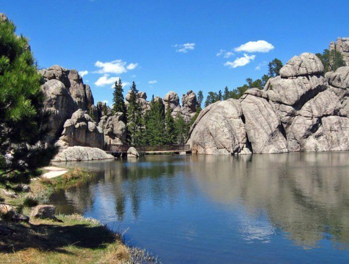 a lake surrounded by large rocks and trees