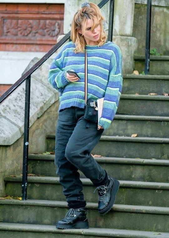 a woman standing on some steps looking at her cell phone