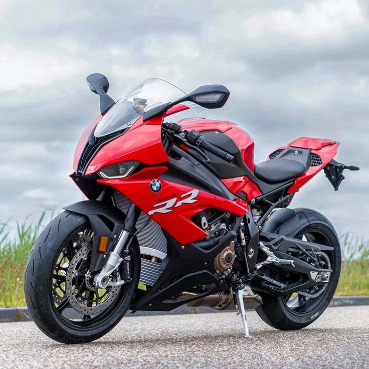 a red motorcycle is parked on the side of the road