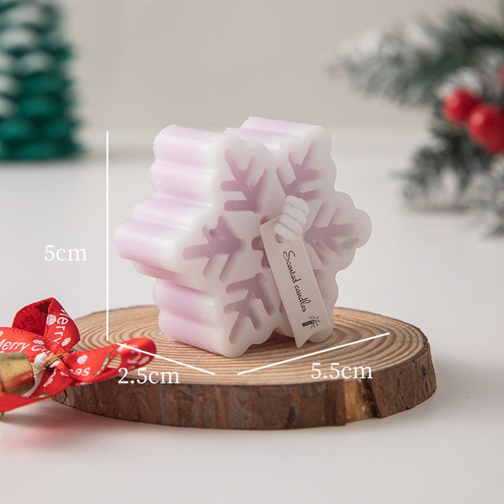 a close up of a soap bar on a wooden slice with a red ribbon around it