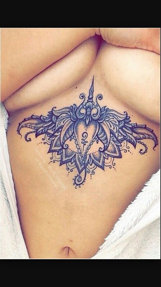 a woman's stomach with an intricate tattoo on her belly and the bottom part of her stomach