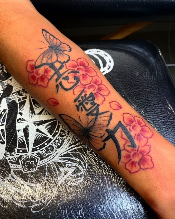 a woman's arm with flowers and an anchor tattoo on the left side of her arm