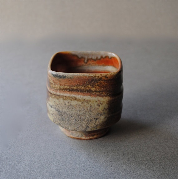 a brown and black cup sitting on top of a table