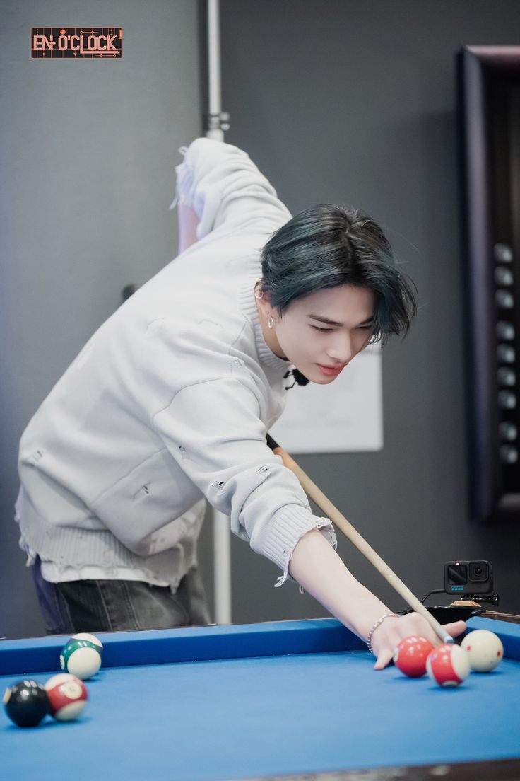 a woman is playing pool on a blue table