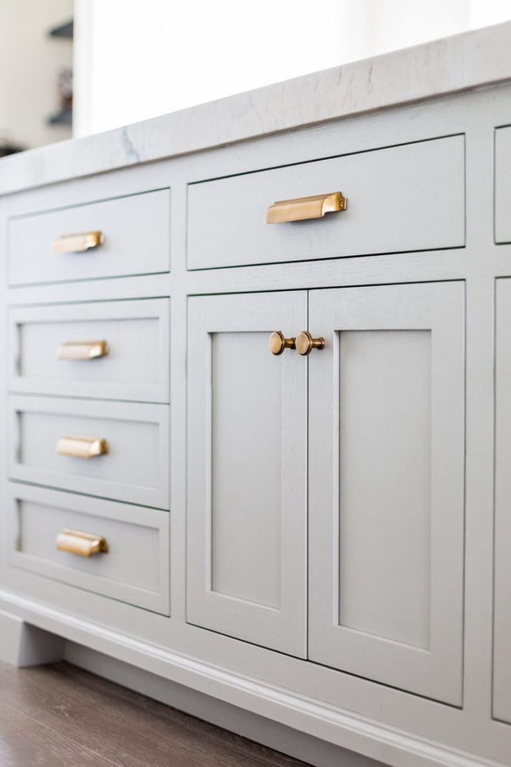 a white cabinet with gold handles and knobs