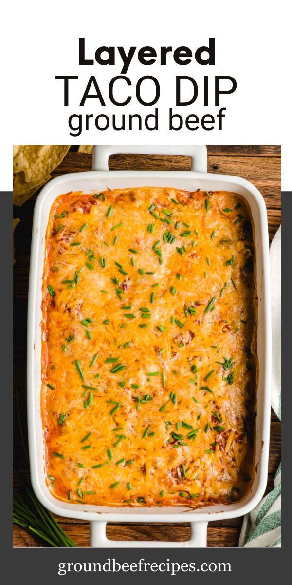 layered taco dip in a white casserole dish with text overlay that reads layered taco dip ground beef