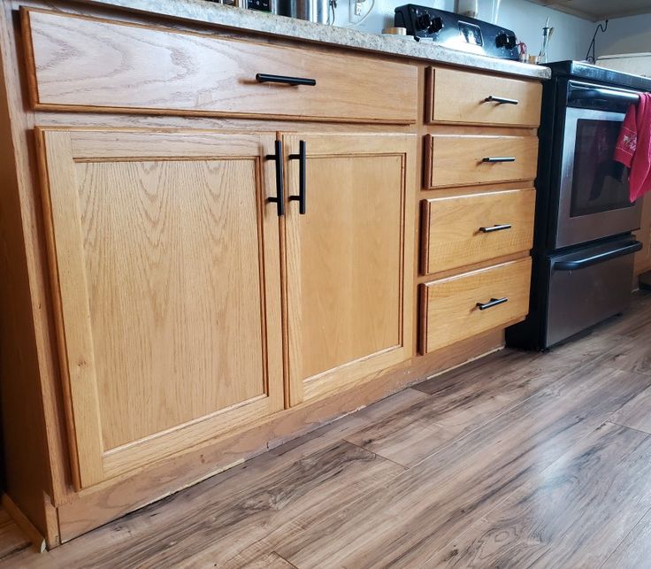 a kitchen with wooden cabinets and stainless steel appliance on the counter top, next to an oven