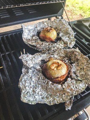 two hot dogs are being grilled on the grill with buns and onions in them