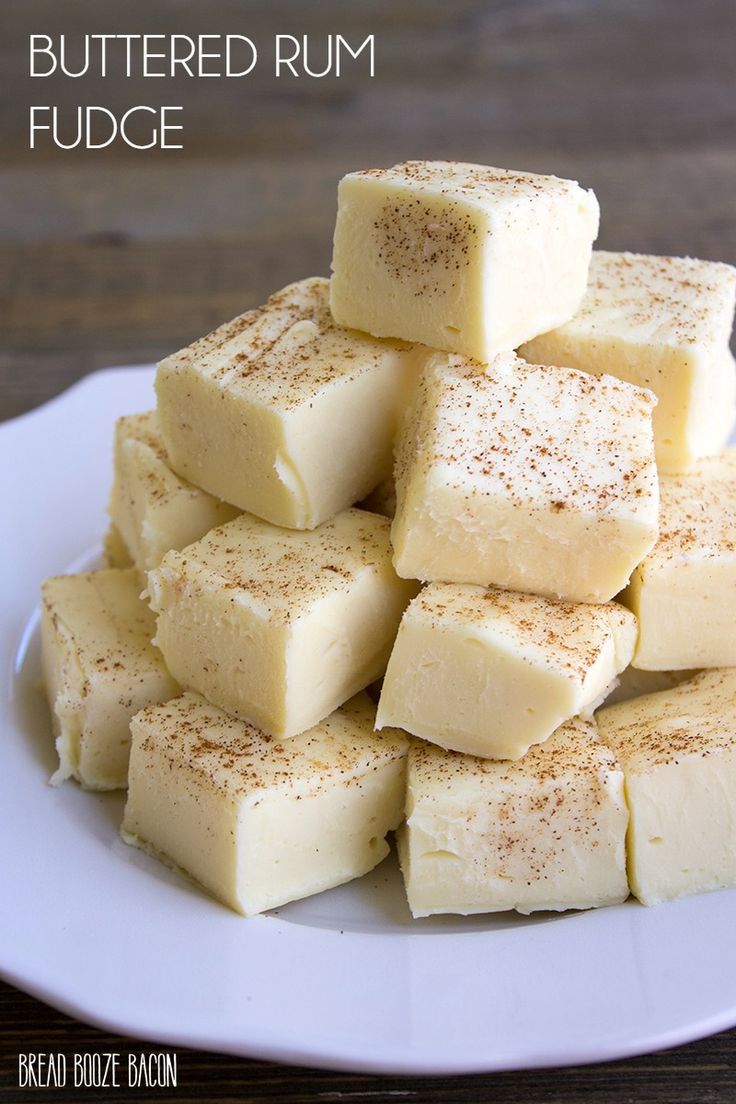 a white plate topped with pieces of fudge covered in cinnamon next to a wooden table