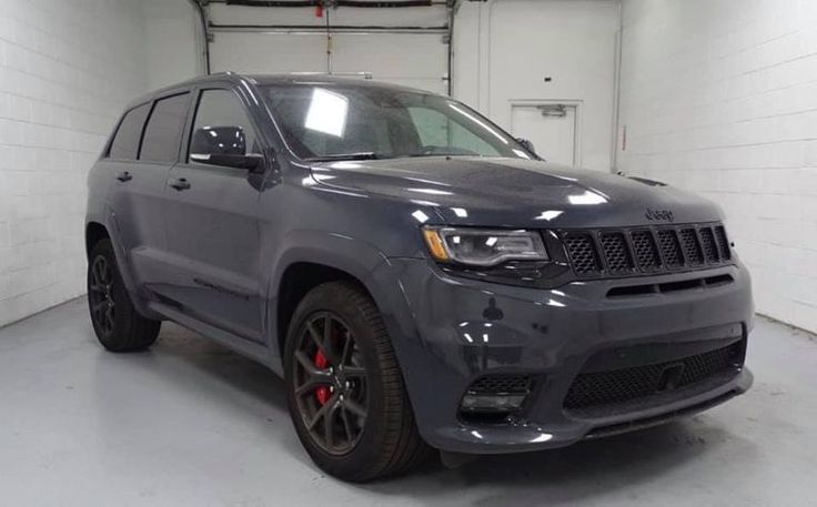 a grey jeep is parked in a garage