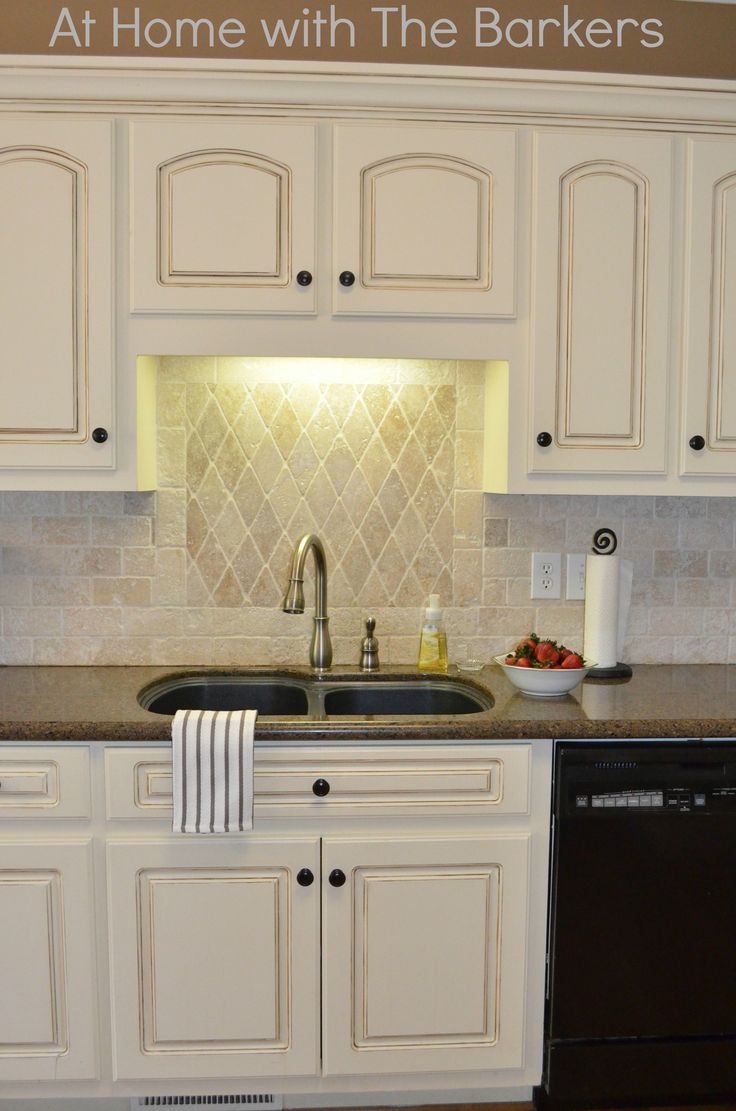 a kitchen with white cabinets and granite counter tops, along with a black dishwasher