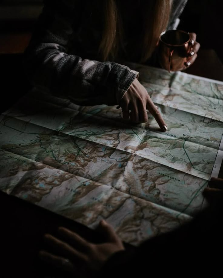 a person pointing at a map on a table