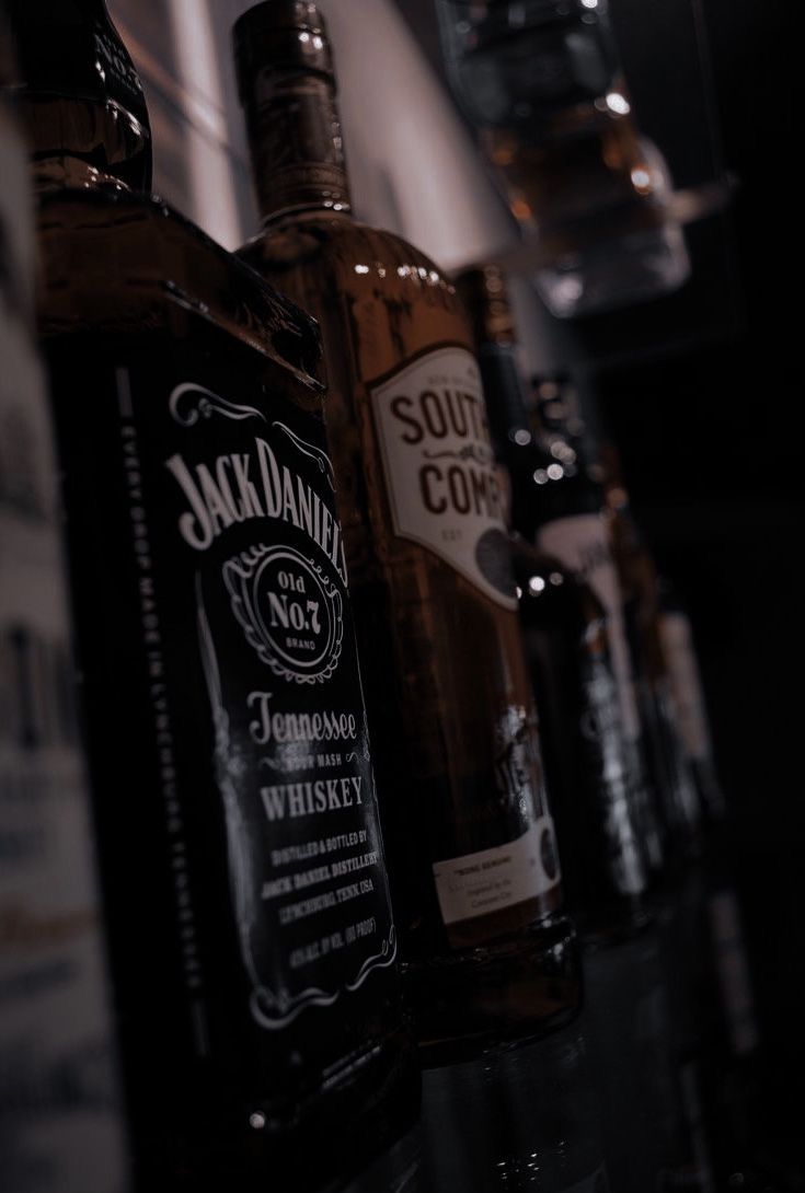 several bottles of whiskey lined up on a shelf