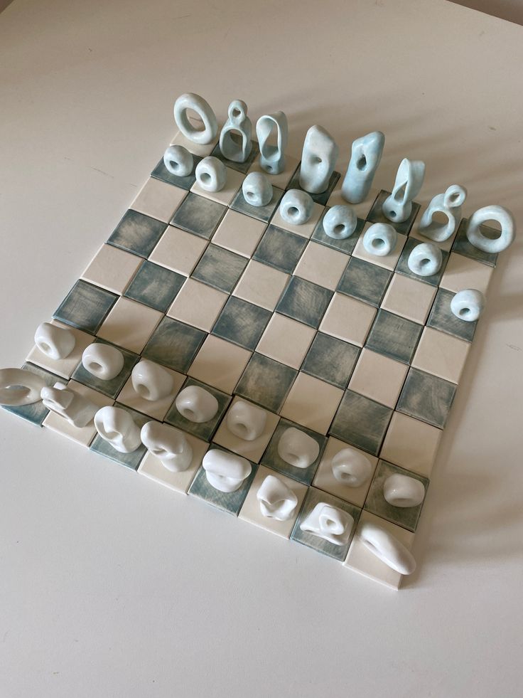 a chess board with letters and numbers on it, sitting on a table in front of a wall