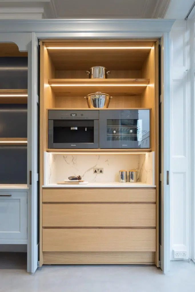 an open cabinet in the middle of a kitchen